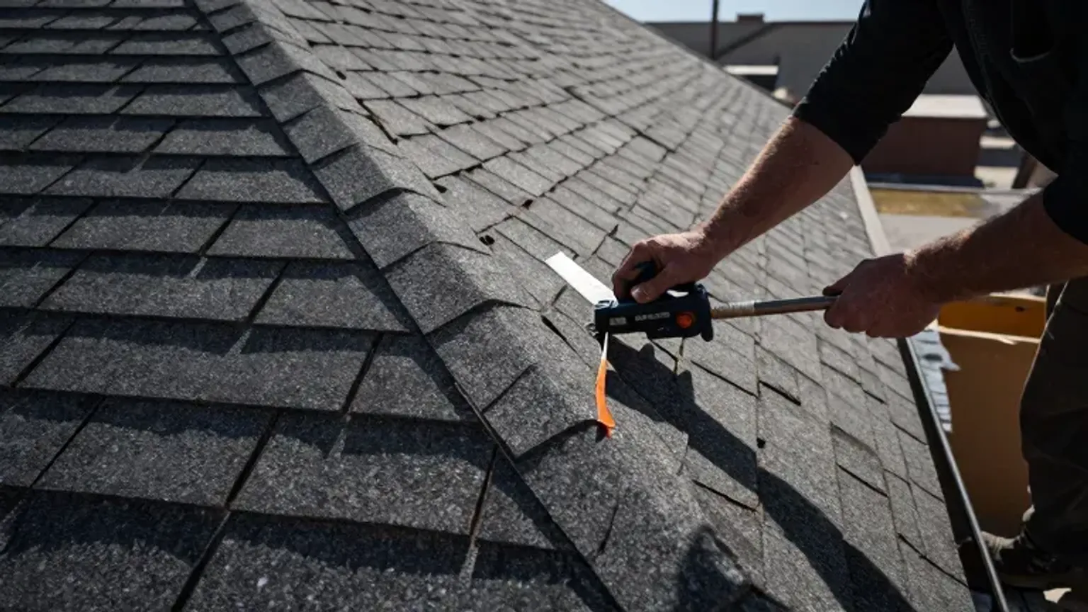 Documentary-style iPhone photo of precision shingle installation at roof valley and ridge detail in Saratoga Springs, Utah. Natural daylight.