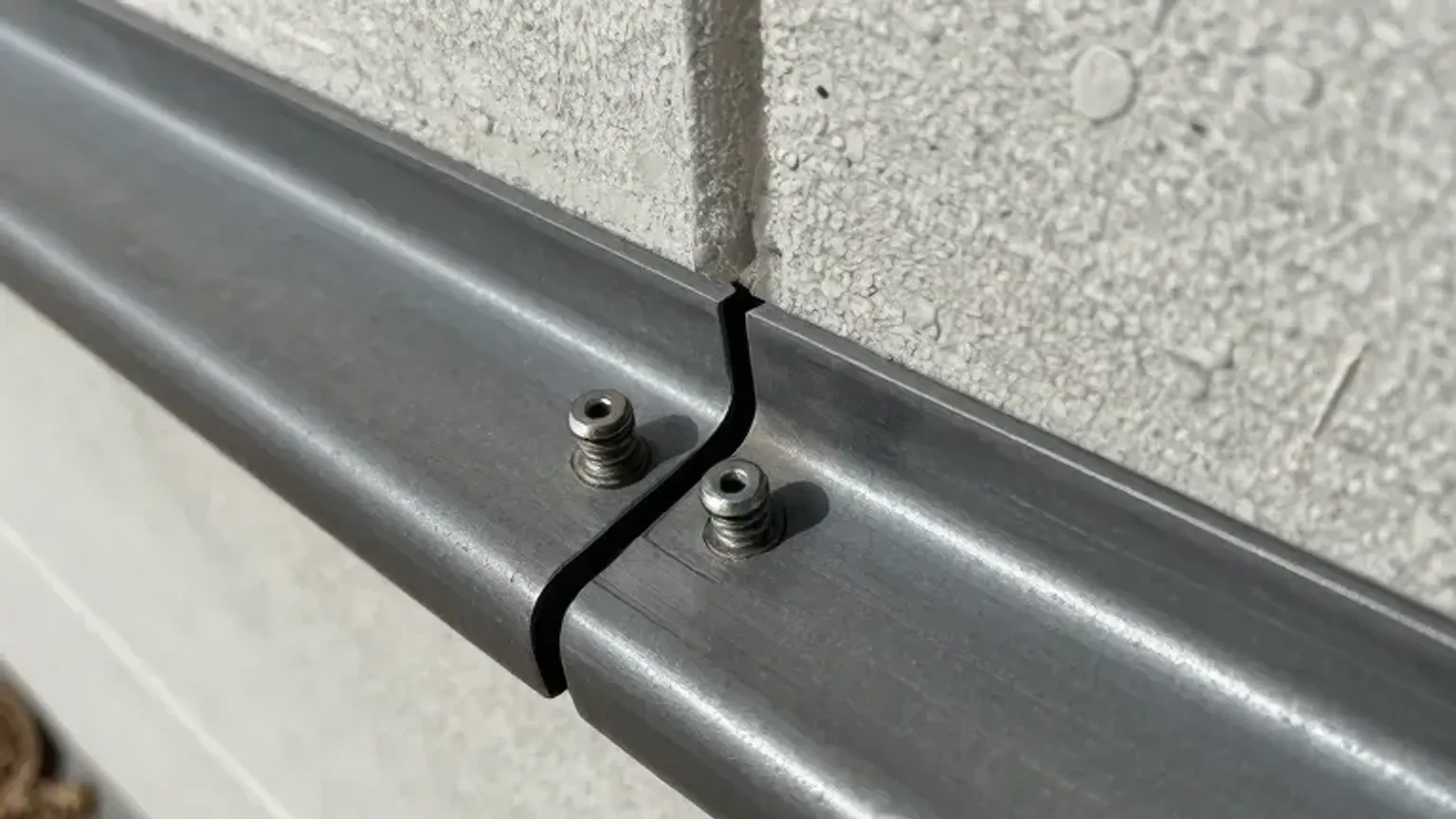 Documentary-style iPhone close-up photo of gutter seam resealing and fastener reinforcement detail in Saratoga Springs, Utah. Natural lighting.