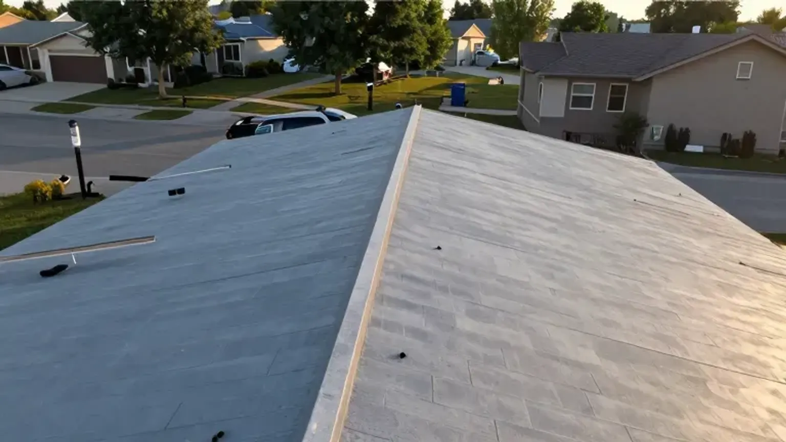 Documentary-style iPhone photo of a completed roof maintenance check with clean roof and gutters on a Saratoga Springs, Utah property. Natural afternoon light.