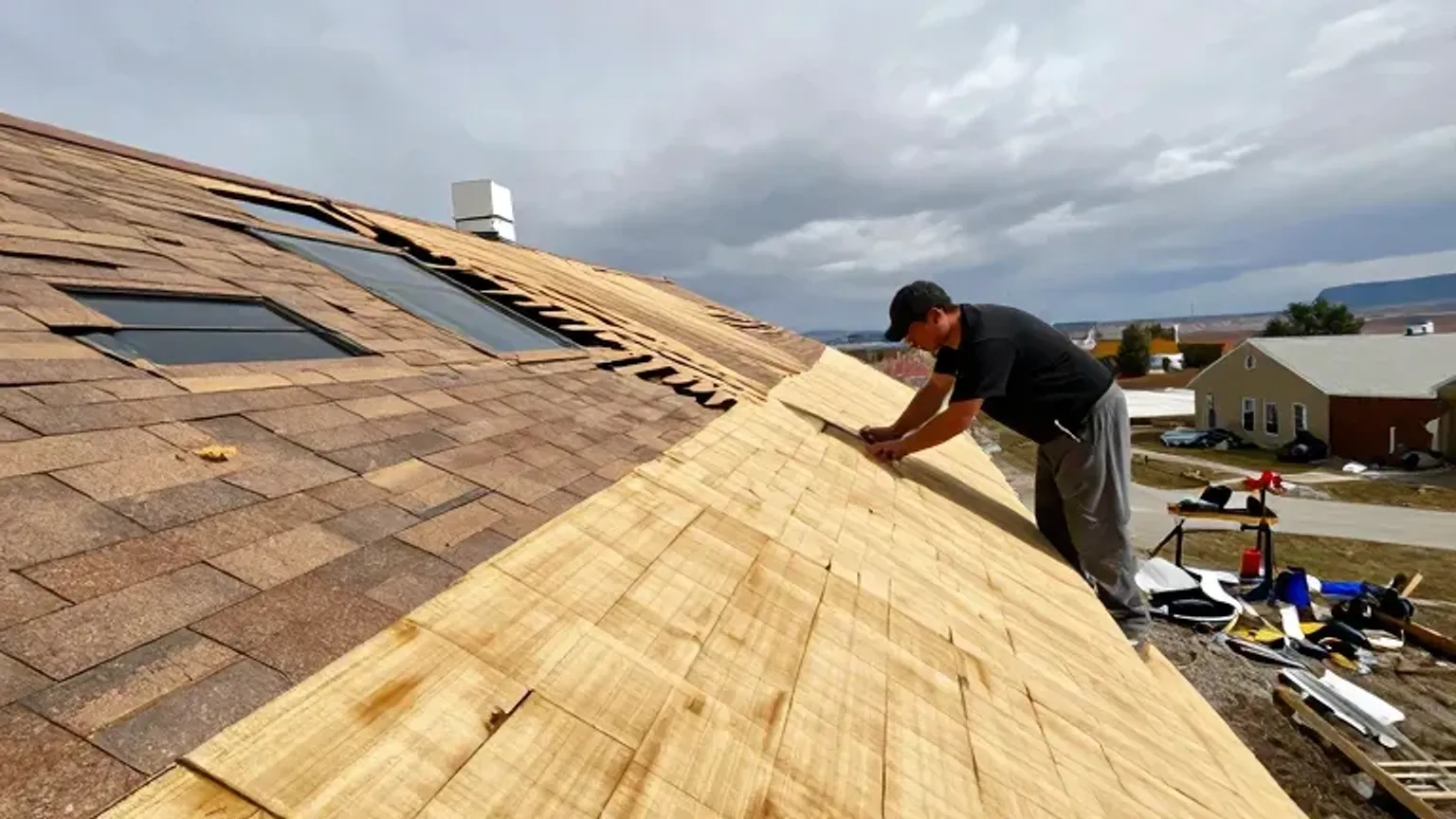Documentary-style iPhone photo of storm-damaged roof section being repaired by contractors in Saratoga Springs, Utah. Natural lighting.