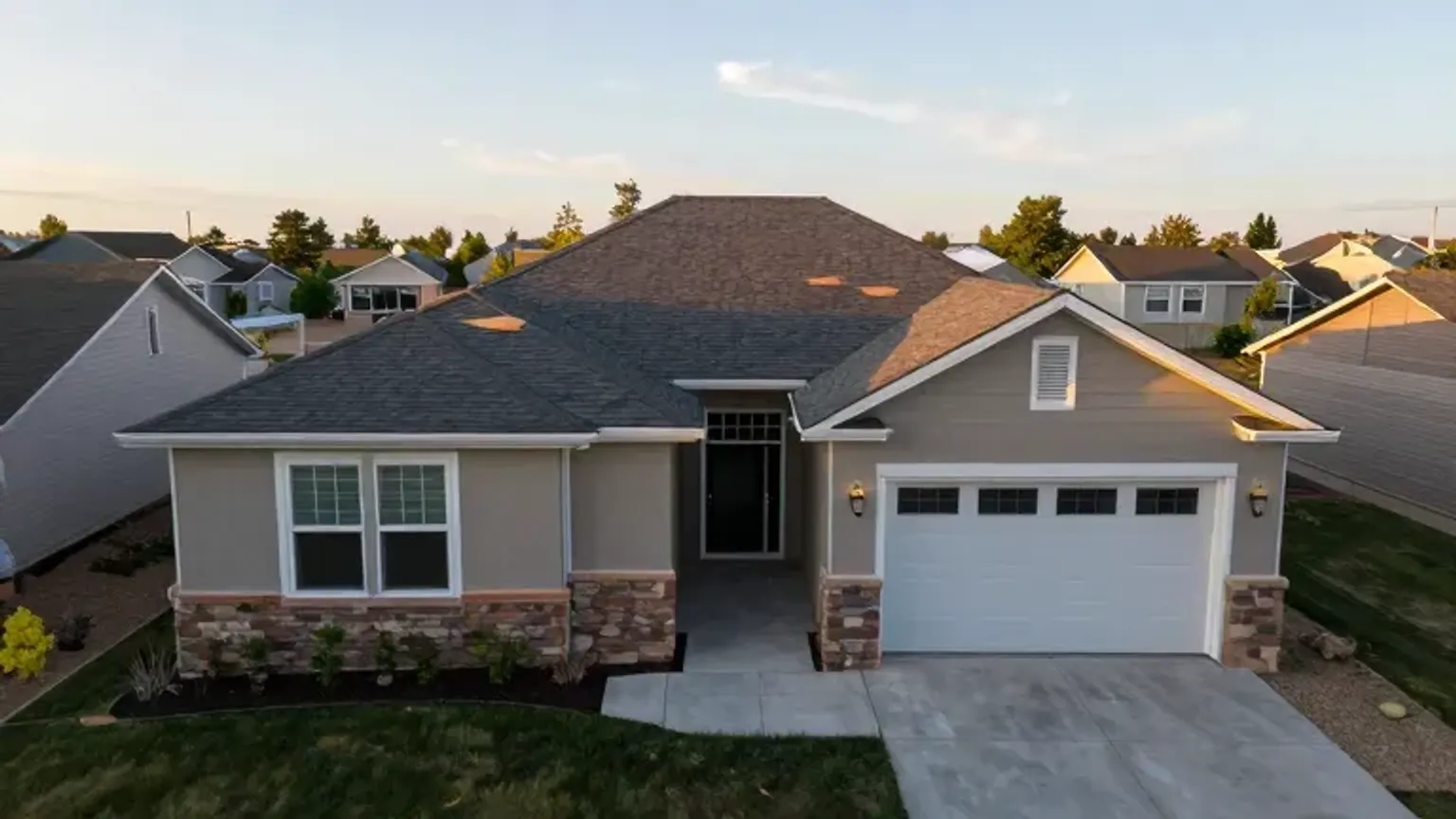 Documentary-style iPhone photo of completed roof replacement with clean curb appeal on a home in Saratoga Springs, Utah. Natural daylight.