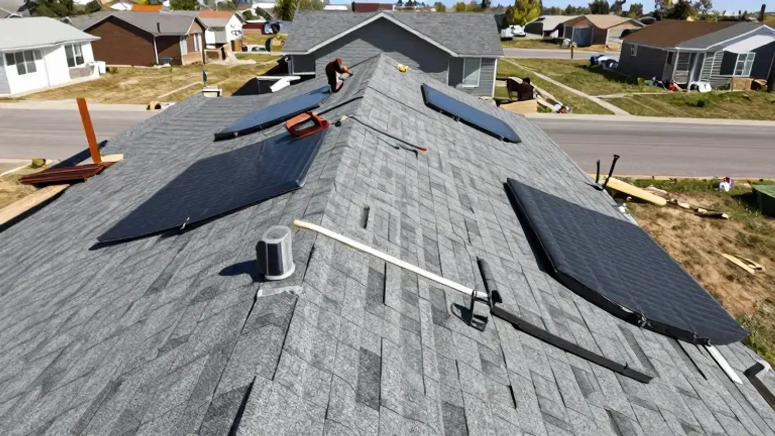 Documentary-style iPhone photo of roofers replacing damaged shingles after wind exposure on a suburban home in Saratoga Springs, Utah. Natural daylight.